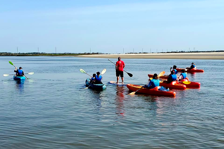 a group of people rowing a boat in a body of water